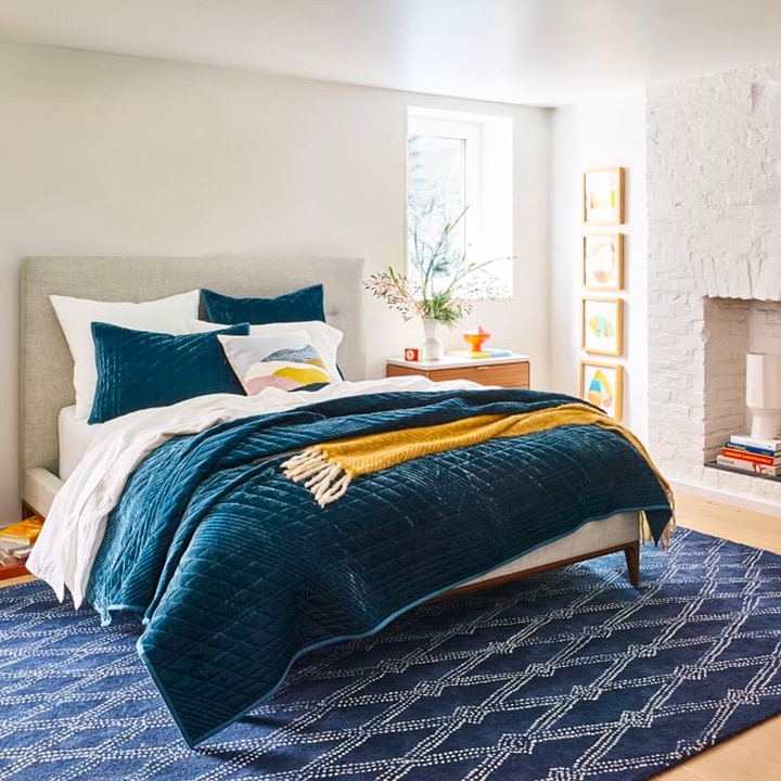 Velvet blue coverlet on made bed