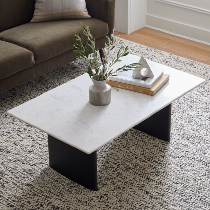 Marble top coffee table with books and a vase
