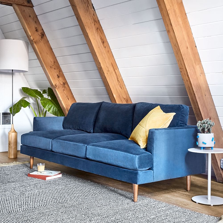 blue velvet couch and textured rug