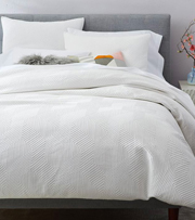 Bed with white duvet cover.