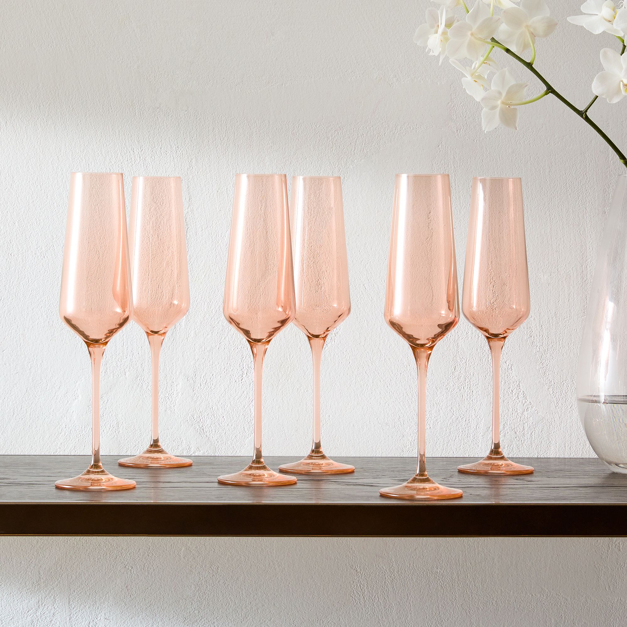 Six pink champagne flutes on a table