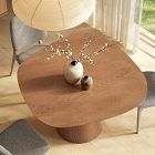 Round wooden table with pedestal base and a small white vase with decorative branches on top