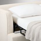 Close view of sofa arm with cushions and blanket