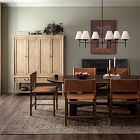 A mid-century wooden dining room set including a wooden sideboard, a long dining table, and chairs in a dimly lit room