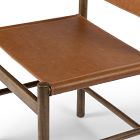 Close-up of a tan leather seating surface on a wooden chair showing the smooth leather and joint