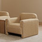Woven beige armchair with rounded back and armrests shown in profile.