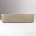 Long beige upholstered sofa or chaise length front view against white background.