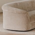 Close-up of the rounded arm of the beige sofa showing soft upholstery and seam detail.