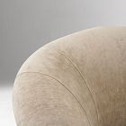 Close-up of a curved back corner of the beige sofa showing soft fabric and stitching.