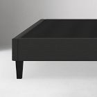 Close-up of black bed frame corner with sturdy leg and woven texture