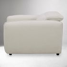 Cream-colored armchair photographed from the side with footrest retracted.