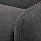 Close-up of the stitching along the seam on the gray fabric of an armchair.