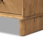 Corner of a wooden dresser with visible grain and base support.