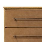 Close-up of two metal handles on a wooden dresser