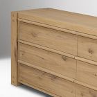 Side view of a wooden dresser with multiple drawers and visible grain