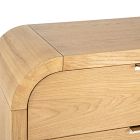 Rounded corner of a light wood dresser with curved edge and visible join