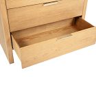 Open wooden drawer pulled out from a light wood dresser showing interior storage