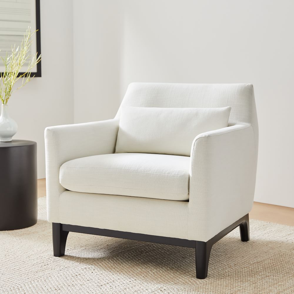 Harvey chair in beige fabric with dark wooden legs in a room