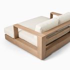 Wooden sofa with white cushions and visible slatted base