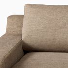 Close-up of the backrest and armrest of a beige sofa.