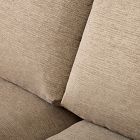 Close-up of the fabric texture and cushion of a beige sofa.