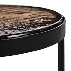 Edge of black rounded table with glossy marbled top and black frame