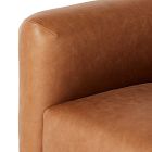 Close-up of the front left corner of the armchair showing leather texture.