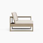 Single-seat lounge chair with beige cushion and wooden frame, armrest visible.
