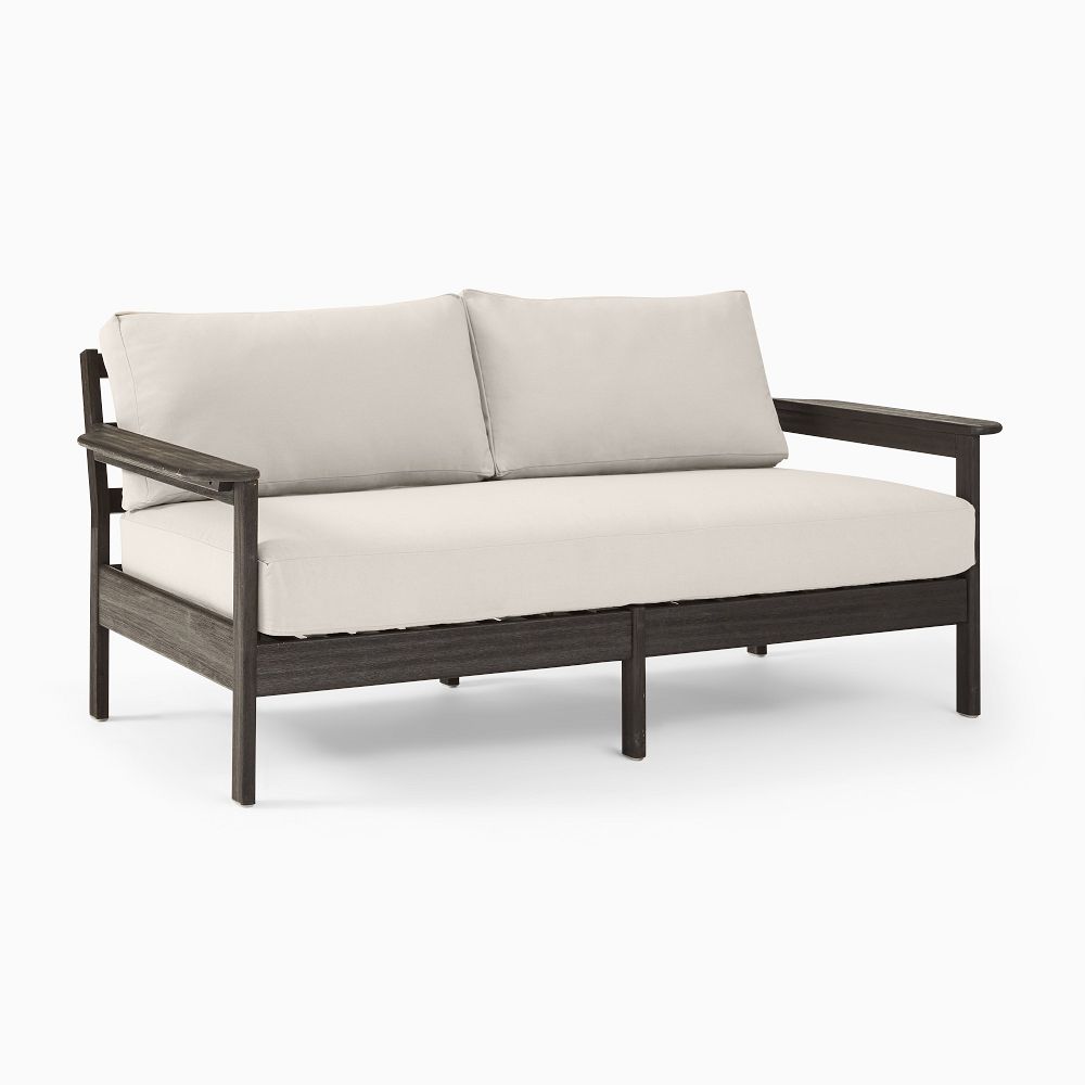 Wooden loveseat with beige cushions on white background.