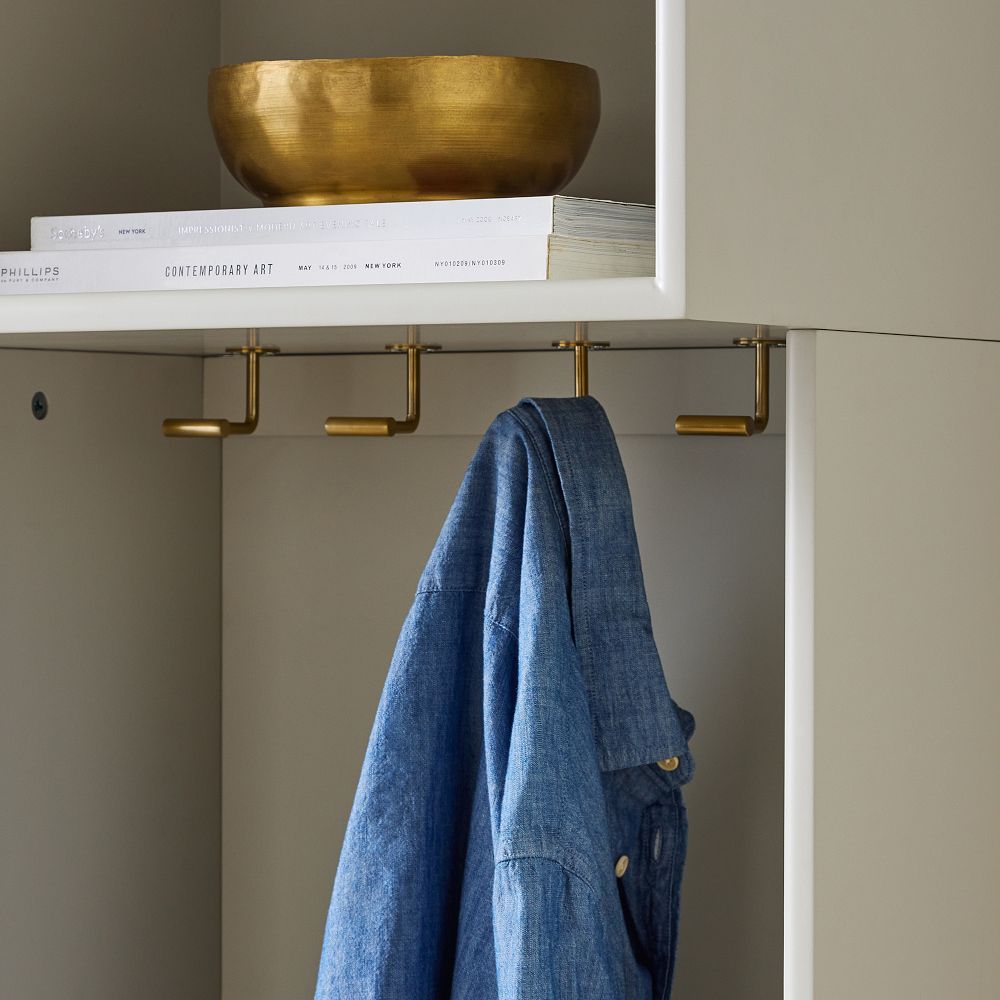 Gold hooks along underside of upper shelf holding a blue jacket