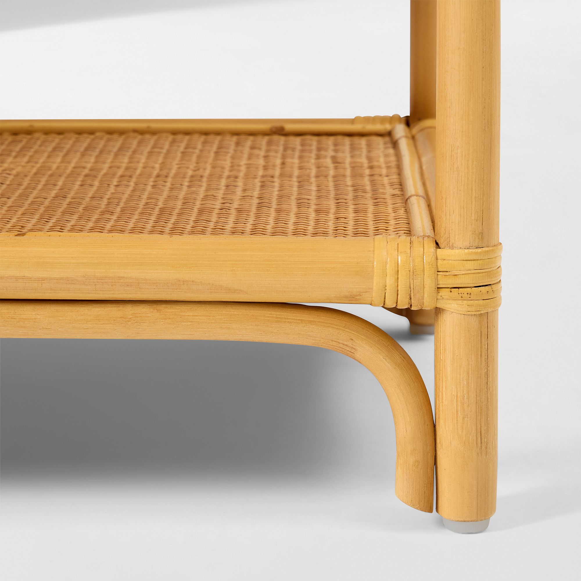 Bottom edge of curved rattan shelf with leg and corner wrap