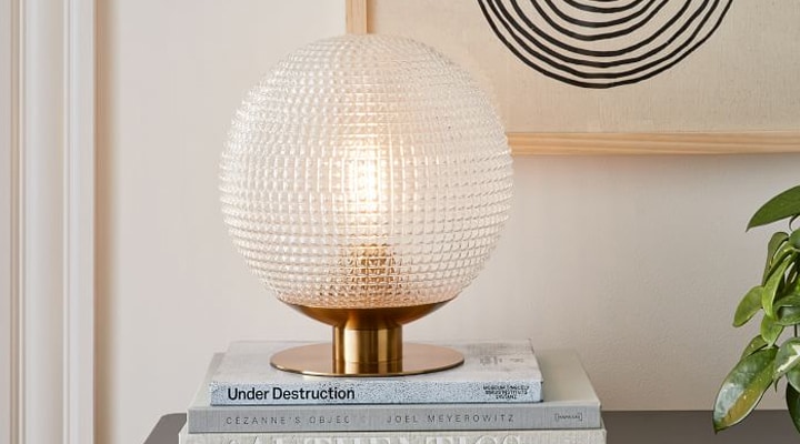 Gold prismatic glass table lamp sitting on books