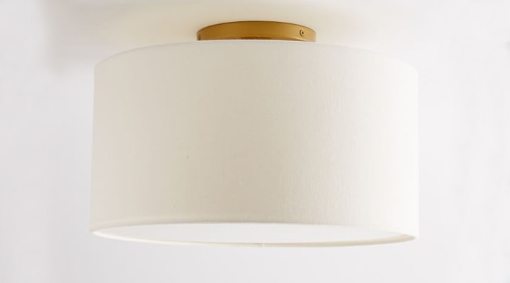 Gold flushmount light with white fabric shade