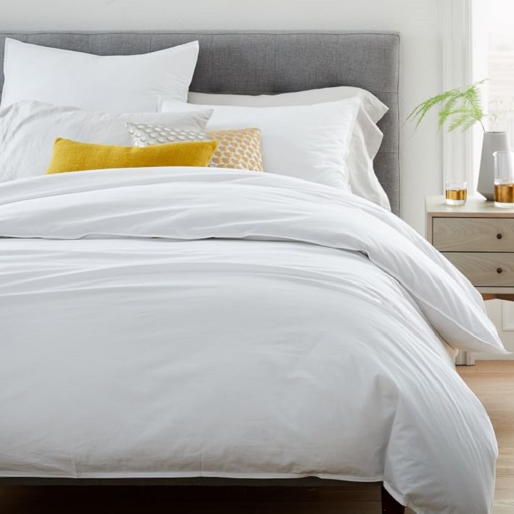 Bed with white cotton duvet and pillows