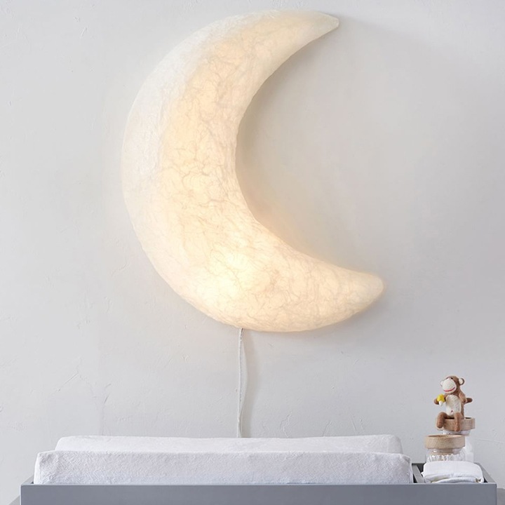 Papier-mache light up moon hanging over changing table.