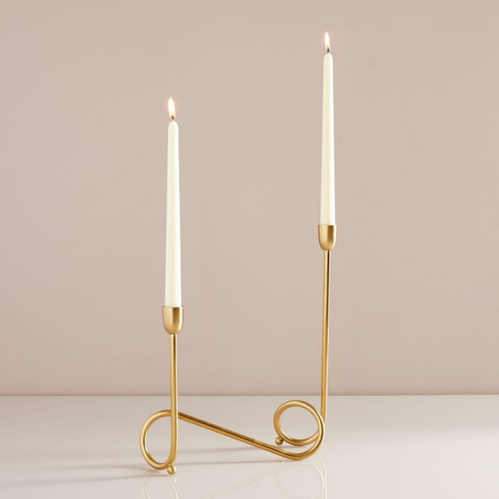 modern gold candlestick with two lit candles