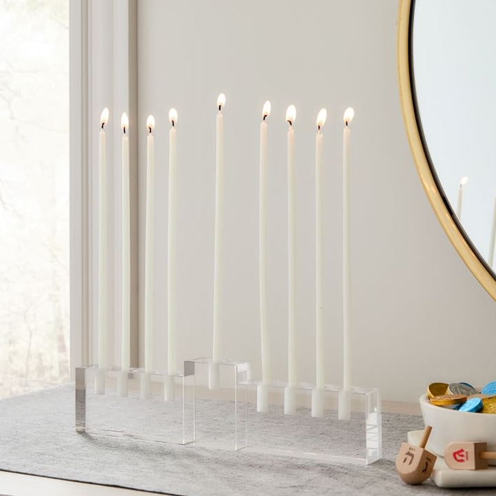 close up of clear modern menorah sitting on mantle