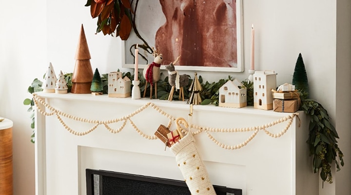 wooden garland and one stocking hanging on mantel with mantel decor