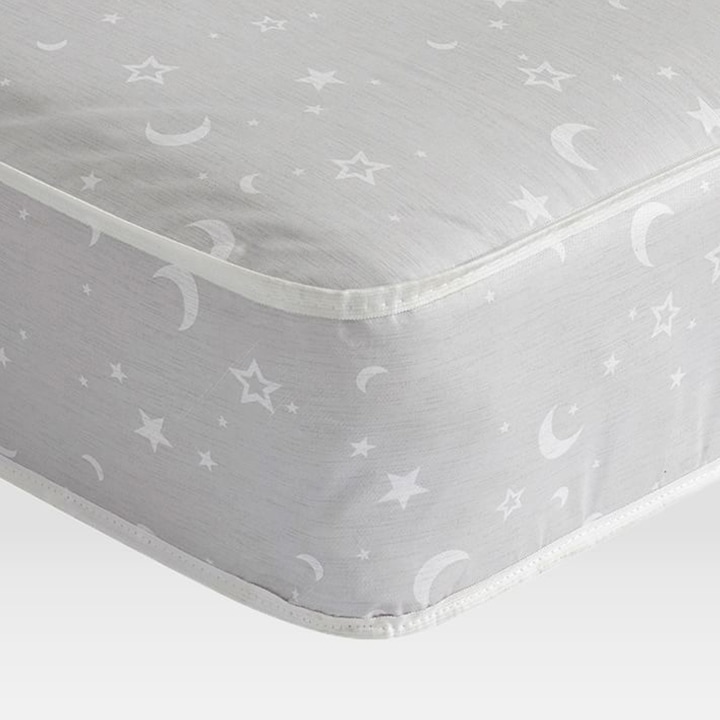 Close up of crib mattress with stars and moons pattern