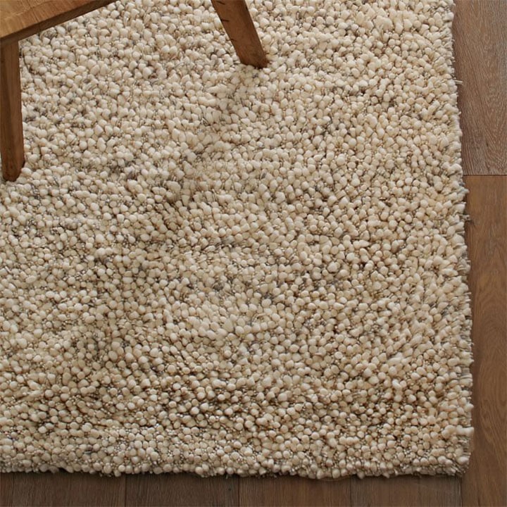 Shag wool rug on wood floorboards