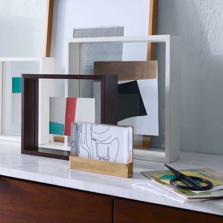 framed modern art sitting on table