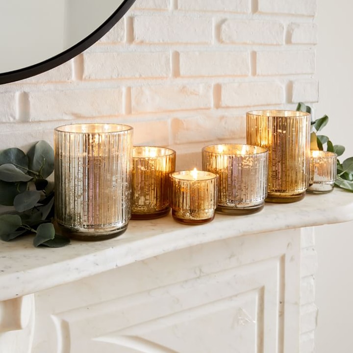gold metallic candles on a fireplace mantel