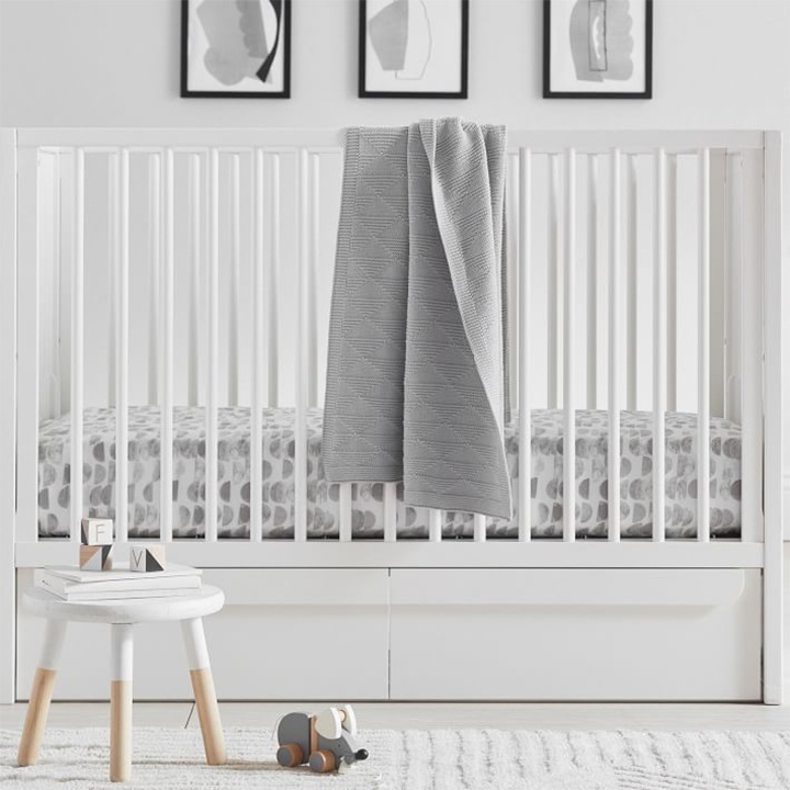 White storage crib in child’s nursery