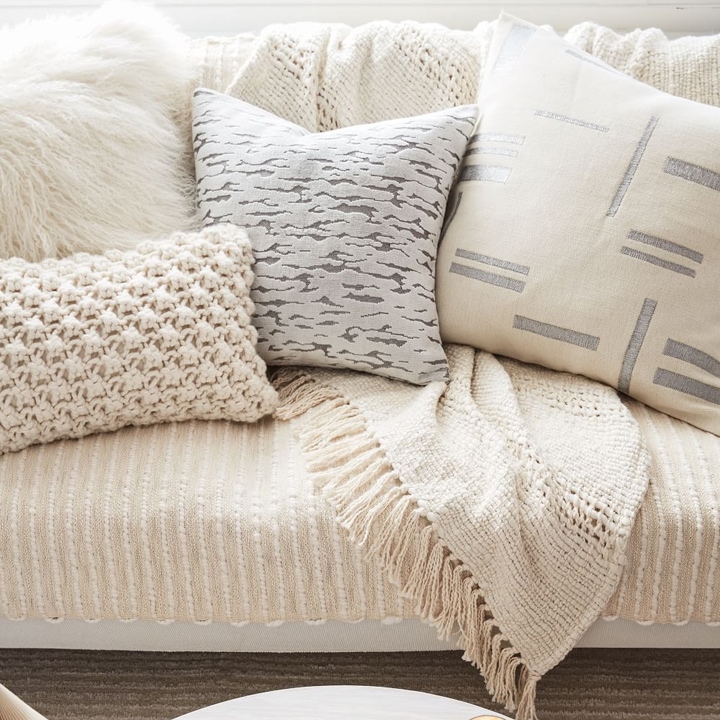 Pile of throw pillows in several different unique fabrics and textures