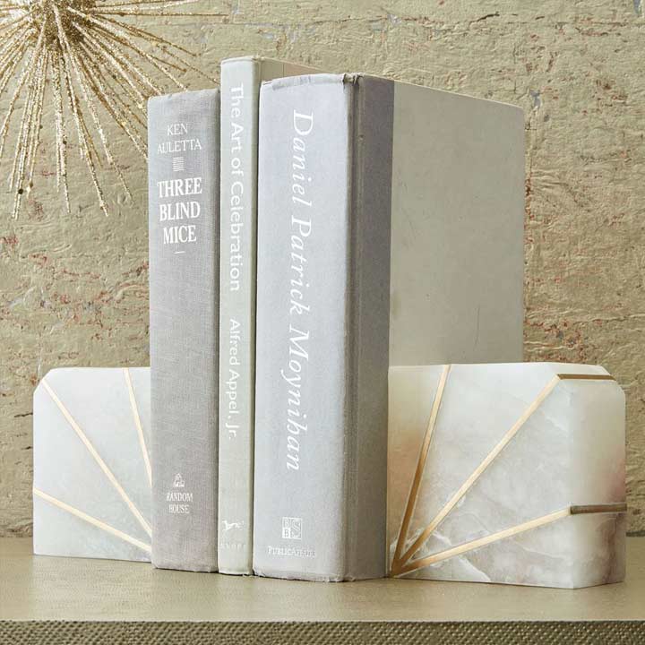 three books sitting between two alabaster and brass bookends