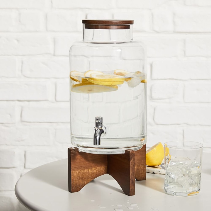 Modern glass pitcher with wooden stand.