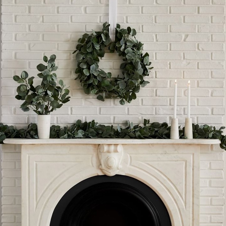 white fireplace with greenery on mantle