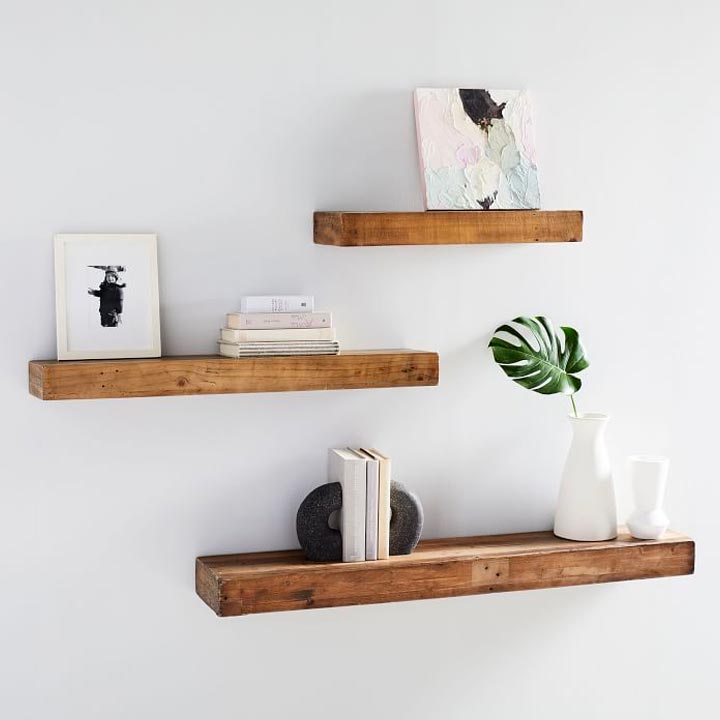 three wooden shelves on wall with decor