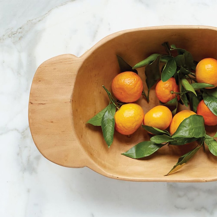 Oranges in wooden bowl.