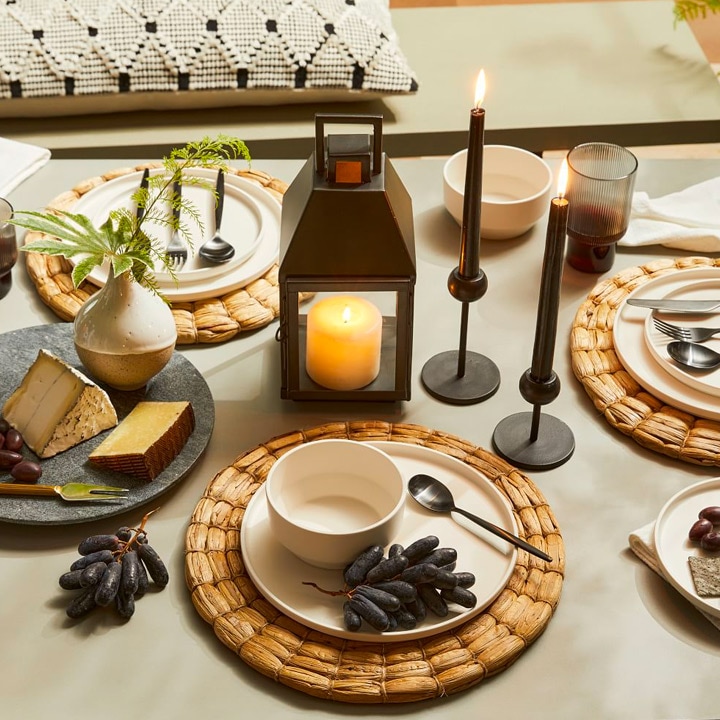 Table setting with lit lantern and candles.